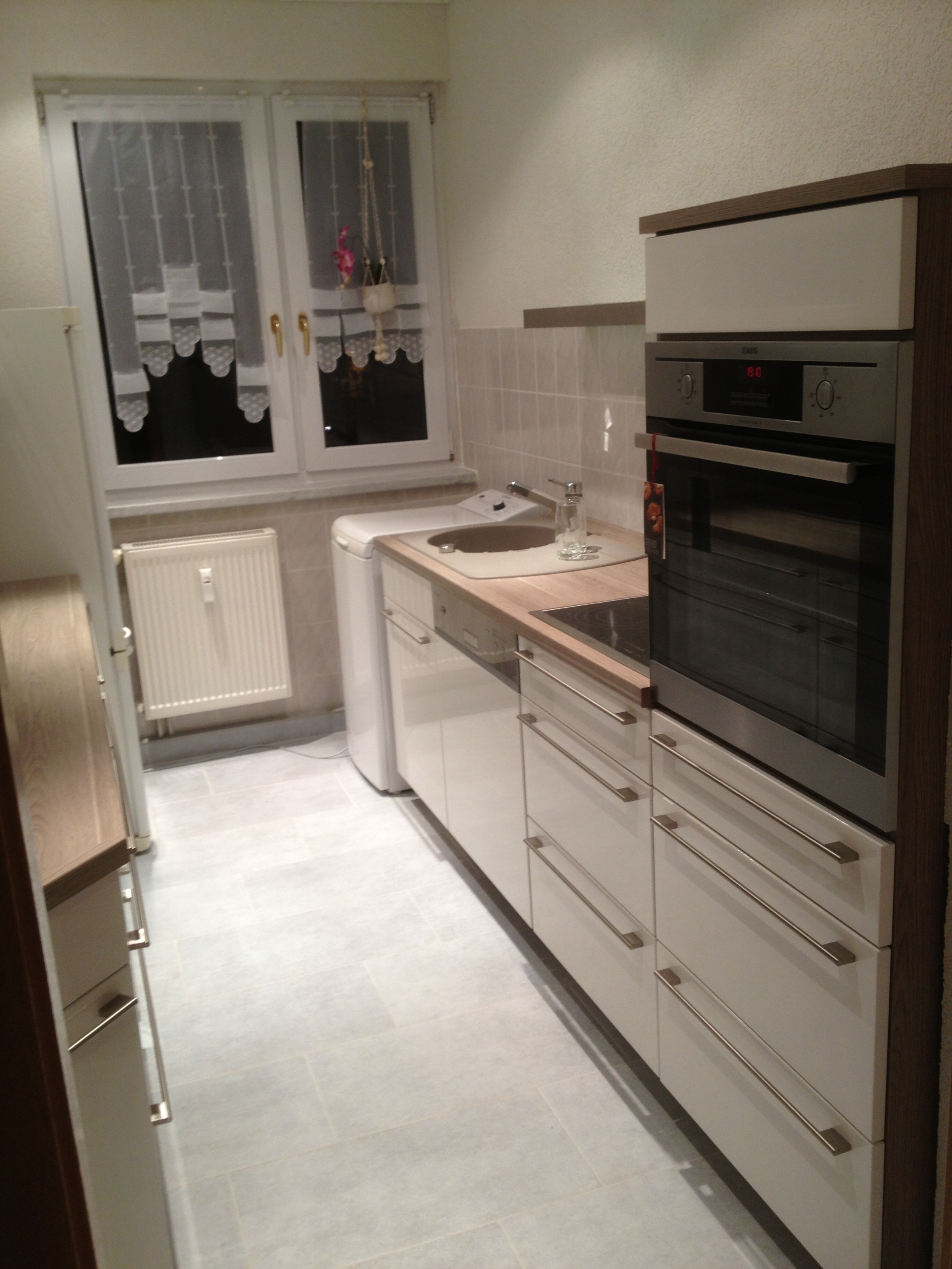 Küche auch auf kleinem Raum, hochgesetzter Backofen, Stangengriffe, Hochglanzdekor weiß