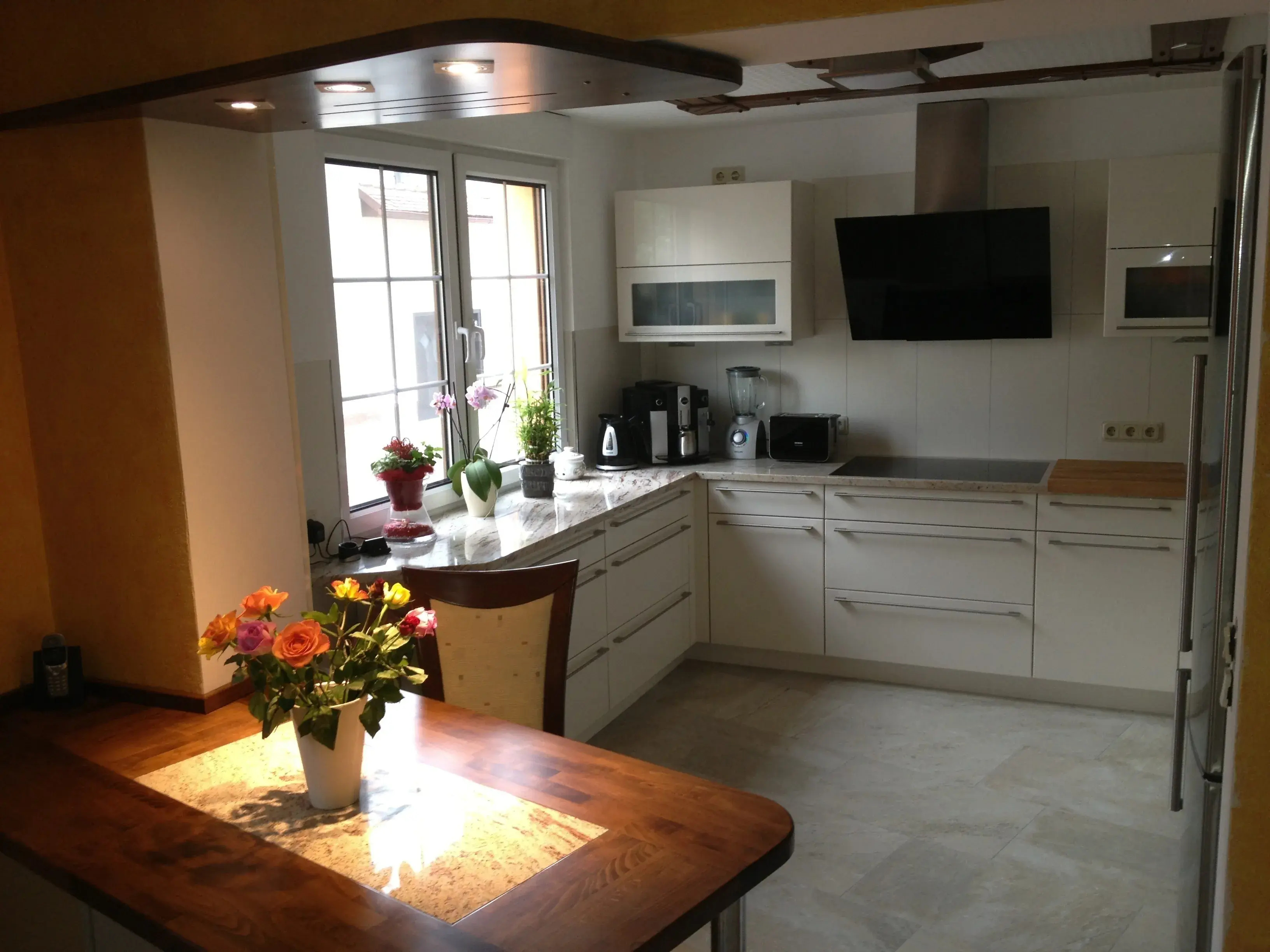 Weiße Küche mit Holztisch