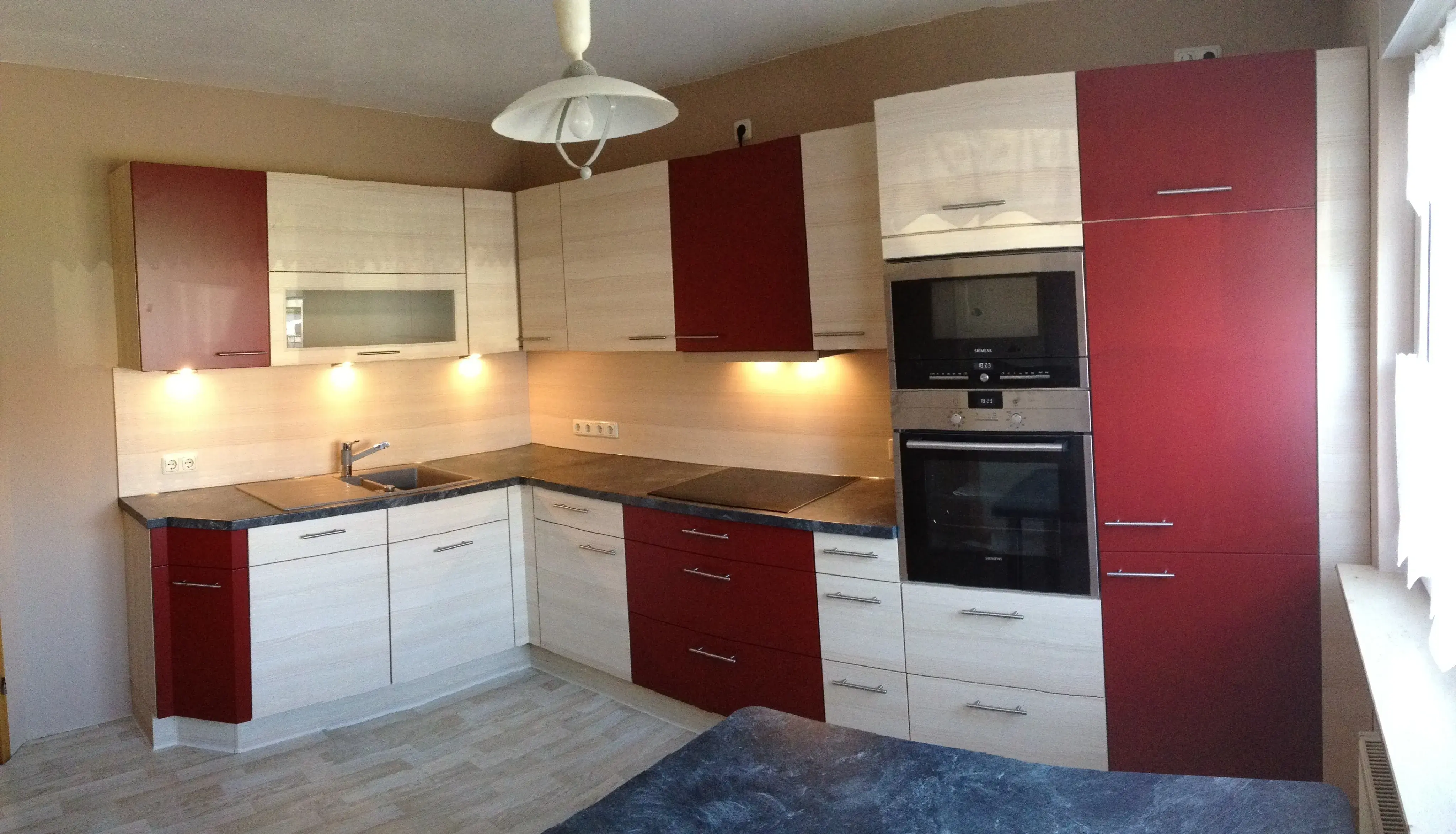 Holzfront mit Absatz bordeaux, hochgebauter Backofen, Hängeschränke mit und ohne Glaseinsatz