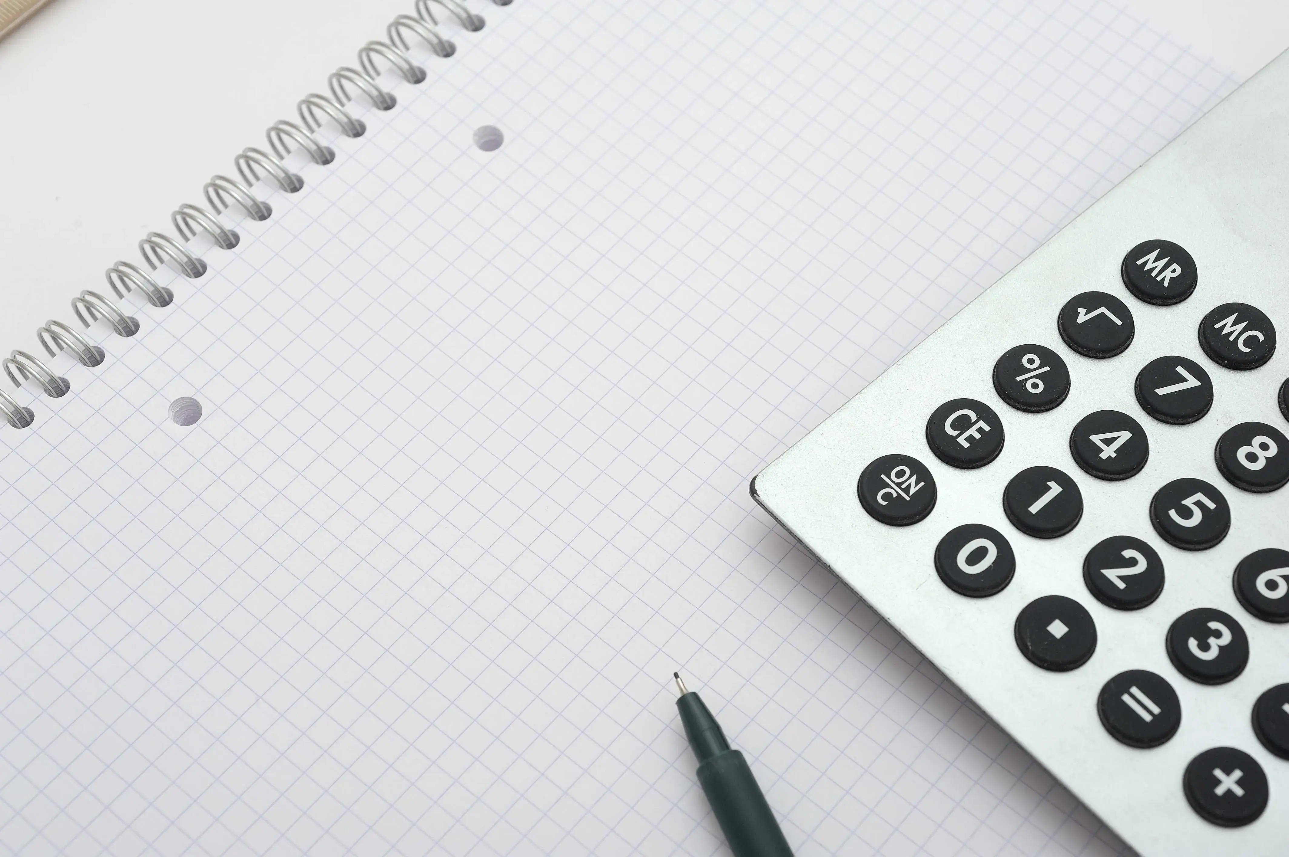 Blatt Schreibblock kariert mit Taschenrechner Stift