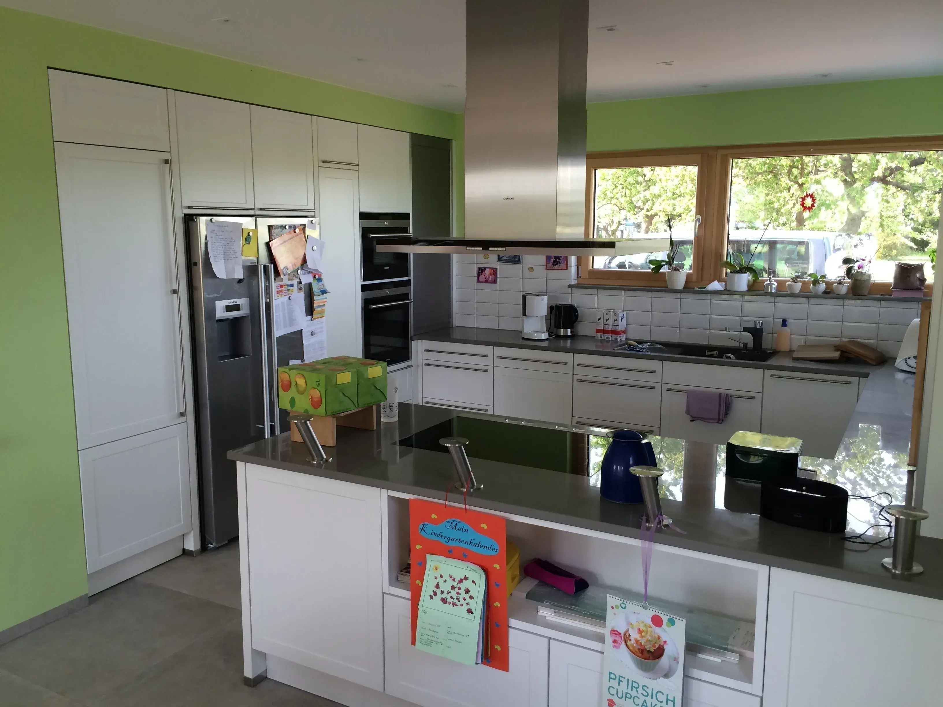 moderner Landhausstil mit Granit, Insellösung, Abzugshaube, hochgesetzter Backofen