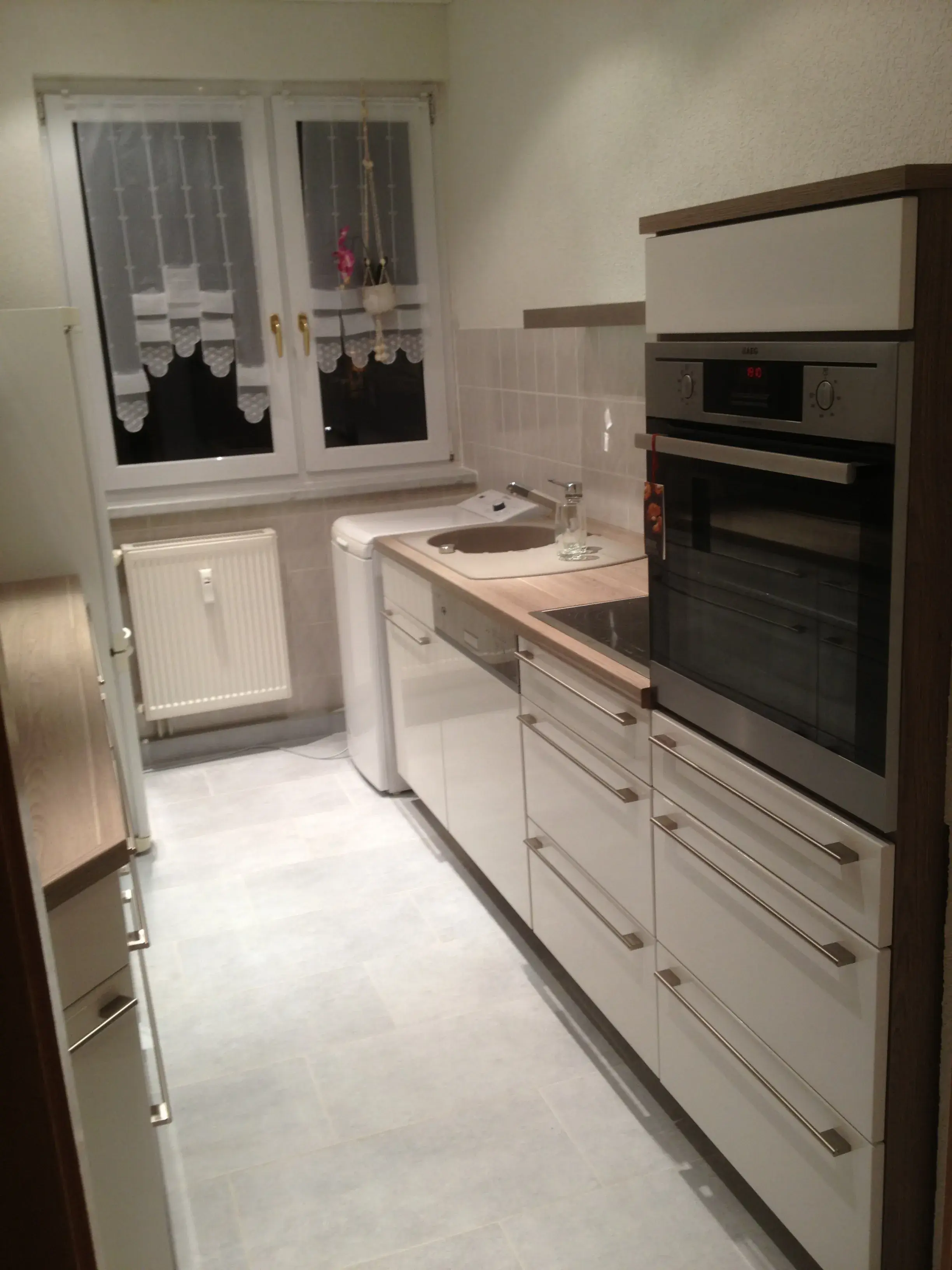 Küche auch auf kleinem Raum, hochgesetzter Backofen, Stangengriffe, Hochglanzdekor weiß