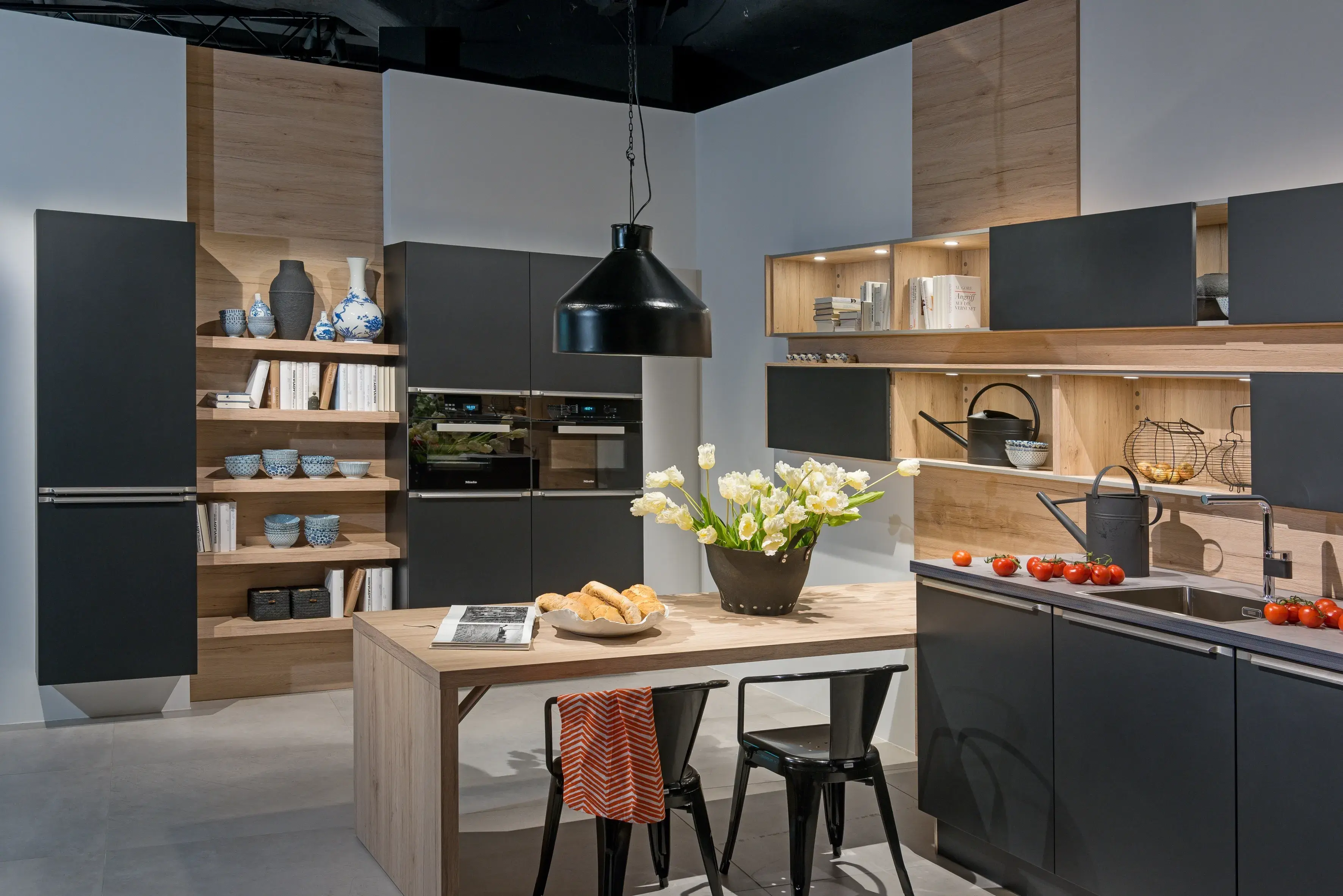 dunkelgraue Küche mit Holzregalen und Esstisch